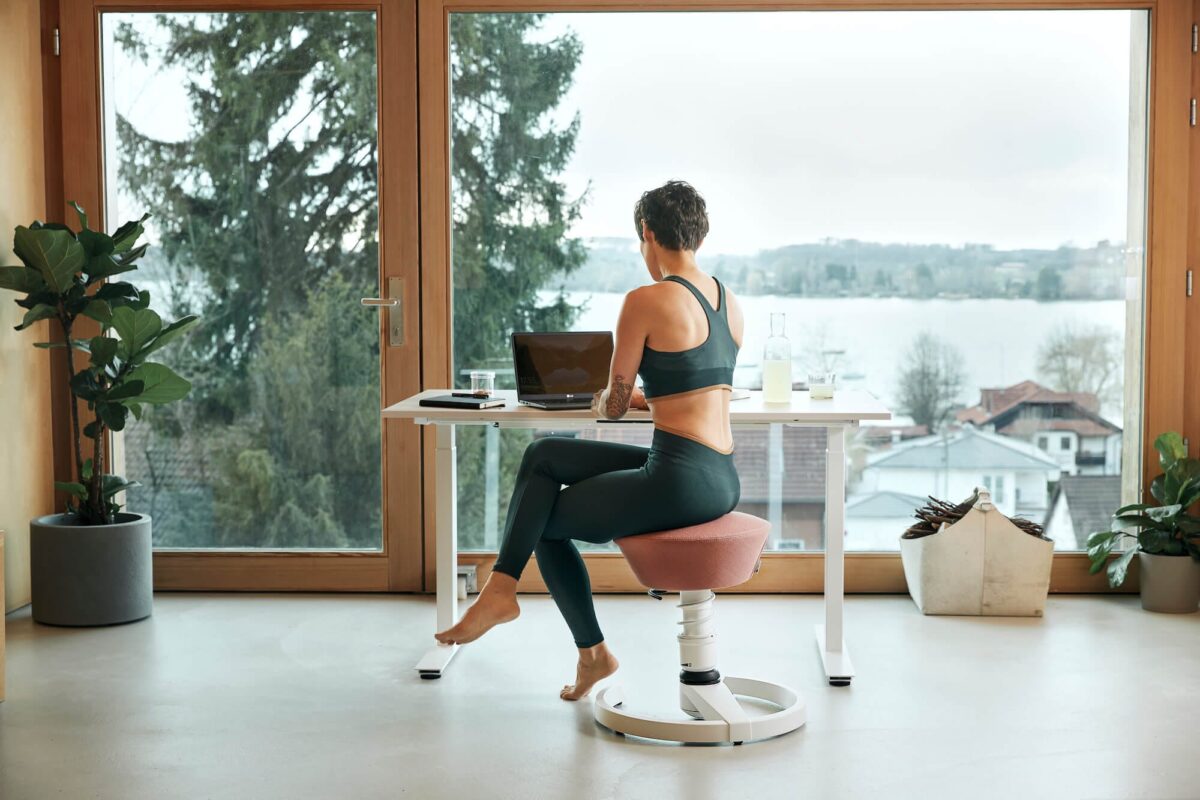 Bureau à domicile aménagé dans un container avec lampe articulée, chaise compacte et rangements sur roulettes