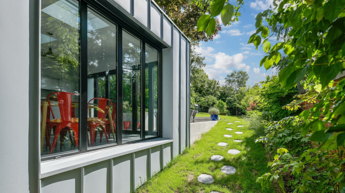 Terrasse extérieure aménagée avec lames de bois, coin repas et jardinières